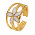 Layered gold floral ring with five-petal white enamel flower centerpiece and intricate textured open band