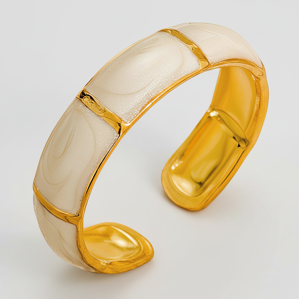 A wide cuff bracelet featuring alternating curved panels of glossy gold and milky white enamel, photographed on a light gray background.