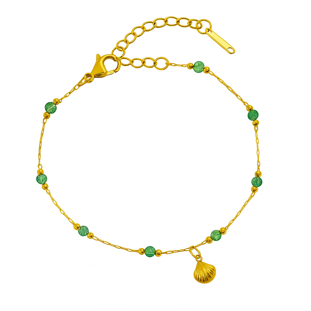 Gold bracelet with green beads and a shell charm on a white background