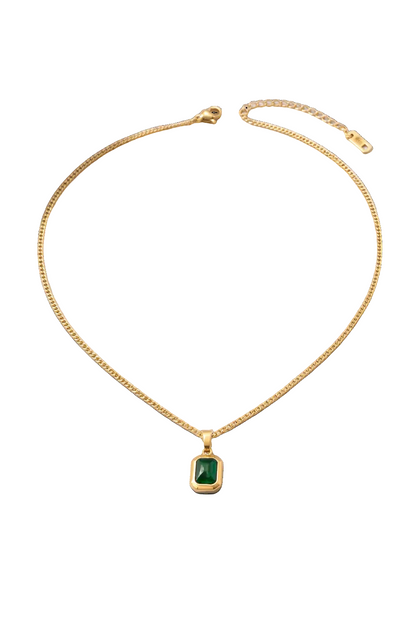 Gold necklace with a green gemstone pendant on a white background